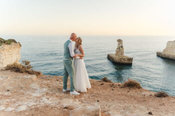 Luxury wedding photography and videography in Algarve & Europe. Elegant, emotional storytelling by Olga & Igor Rosi, Algarve Pictures. Full-day, elopement & destination packages available. Luxury wedding photography and videography in Algarve & Europe. Algarve clifftop wedding venue. Elegant, emotional storytelling by Olga & Igor Rosi, Algarve Pictures. Full-day, elopement & destination packages available. Bride and groom portrait at sunset with dramatic cliffs and ocean in Carvoeiro.